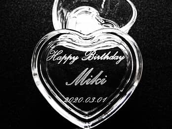 「Happy Birthday、贈る相手の名前、誕生日の日付」を蓋に彫刻した、誕生日プレゼント用のガラス製のハート形小物入れ