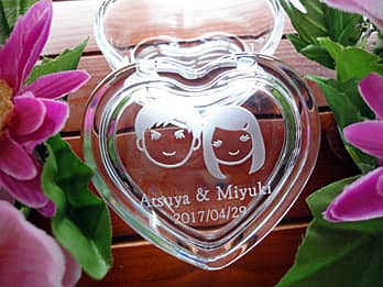 「新郎と新婦の似顔絵と名前、結婚式の日付」を蓋に彫刻した、結婚祝い用のガラス製小物入れ