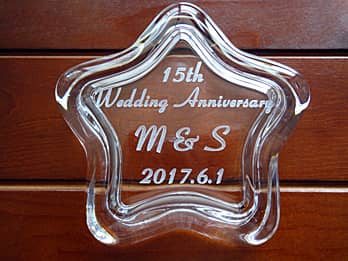 「15th wedding anniversary、旦那様と奥さまのイニシャル、結婚記念日の日付」を蓋に彫刻した、結婚記念日祝い用の星形のガラス製小物入れ