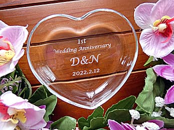 「1st Wedding Anniversary 、旦那様と奥さまのイニシャル、結婚記念日の日付」を中央に彫刻した、結婚記念日祝い用の小皿タイプのガラス製小物入れ