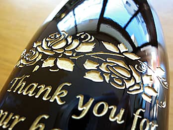 同窓会で恩師へ贈るワインのボトル側面に彫刻した、「Thank you」のクローズアップ画像