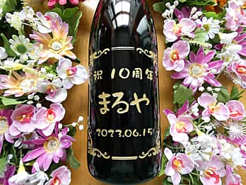 「祝10周年、店名、日付」を一升瓶の側面に彫刻した、飲食店の周年祝い用の日本酒
