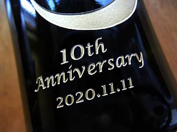 周年祝い用のシャンパンボトルの側面に彫刻した、お祝いメッセージと日付（10th anniversary、2020.11.11）のクローズアップ画像