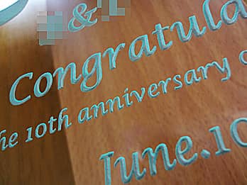 周年祝い用の掛け時計の前面ガラスに彫刻した、「お祝いメッセージ（Congratulations! The 10th anniversary of establishment）」のクローズアップ画像