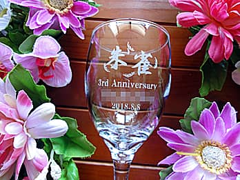 「お店のロゴマーク、3rd Anniversary、スタッフの名前、お祝いをする日付」を側面に彫刻した、周年祝い用のワイングラス