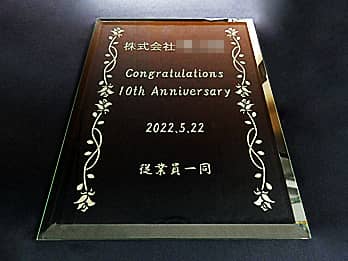 「株式会社○○ Congratulations 10th Anniversary」を彫刻した、会社の周年祝い用のガラス盾