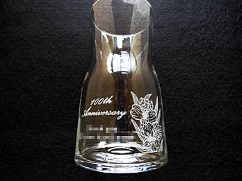 「100th Anniversary、会社名」を側面に彫刻した、100周年記念用のガラス花瓶