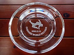 セパタクローのイラストを底面に彫刻した、スポーツ競技の賞品用のガラス製灰皿