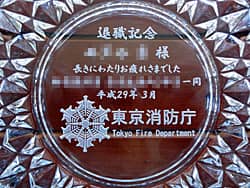 「消防章」「退職記念 ○○様」を底面に彫刻した、消防士の退職記念品用のガラス製灰皿
