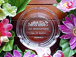 「1st anniversary、店名、日付」を底面に彫刻した、飲食店の周年祝い用のガラス製灰皿