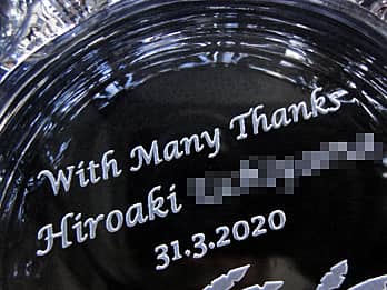 同窓会で恩師へ贈るガラス製灰皿の底面に彫刻した、「With Many Thanks、先生の名前、同窓会の日付」のクローズアップ画像