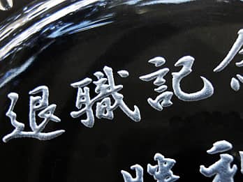 定年退職の記念品用のガラス製灰皿の底面に彫刻した「退職記念」のクローズアップ画像
