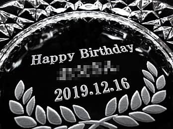 「お祝いメッセージ、贈る相手の名前、誕生日の日付」を底面に彫刻した、誕生日プレゼント用のガラス製灰皿