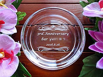 「3rd anniversary、店名、日付」を底面に彫刻した、バーの周年祝い用のガラス製灰皿