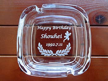 「トカゲのイラスト、Happy Birthday、贈る相手の名前、誕生日の日付」を底面に彫刻した、誕生日プレゼント用のガラス製灰皿