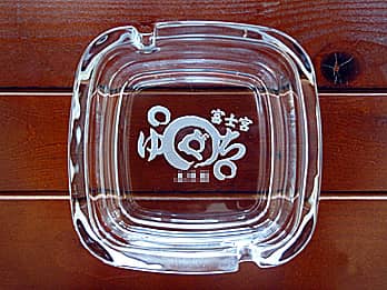 ロゴマークを底面に彫刻した、飲食店の開店祝い用のガラス製灰皿