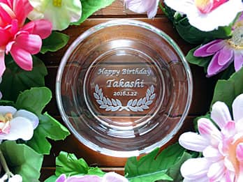 「Happy birthday、贈る相手の名前、誕生日の日付」を底面に彫刻した、誕生日プレゼント用のガラス製灰皿