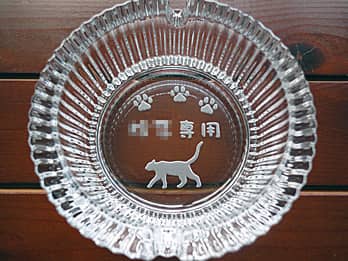 ネコのイラストを底面に彫刻したガラス製灰皿