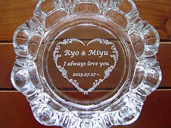 「旦那様と奥さまの名前、結婚記念日の日付」を底面に彫刻した、結婚記念日の贈り物用のガラス製灰皿