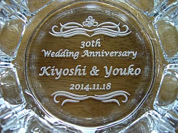「30th Wedding Anniversary、旦那様と奥さまの名前、結婚記念日の日付」を底面に彫刻した、結婚記念日のプレゼント用のガラス製灰皿