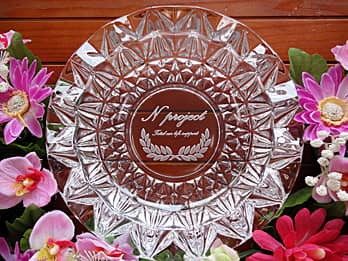 会社の名前とキャッチコピーを、底面に彫刻した丸形のガラス製灰皿（開業祝いの贈り物用）
