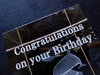 誕生日プレゼント用のガラス製オブジェの側面に彫刻した、「Congratulations on your Birthday」のクローズアップ画像