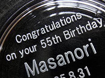 誕生日プレゼント用の灰皿底面に彫刻した、「お祝いメッセージ、名前、誕生日の日付」のクローズアップ画像