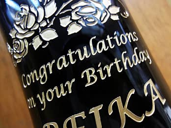 誕生日プレゼント用のワインボトル側面に彫刻した、「お祝いメッセージ」のクローズアップ画像