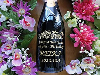 「Congratulations on your birthday、贈る相手の名前、誕生日の日付」をボトル側面に彫刻した、誕生日プレゼント用のシャンパン