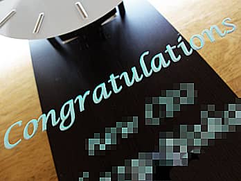 誕生日プレゼント用の掛け時計の前面ガラスに彫刻した、「Congratulations」のクローズアップ画像