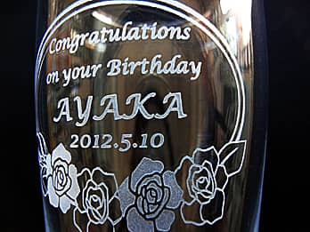 誕生日プレゼント用のグラス側面に彫刻した、「Congratulations on your Birthday、贈る相手の名前、誕生日の日付」のクローズアップ画像