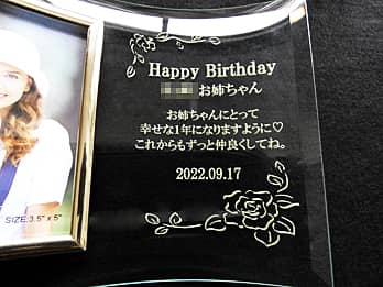 「Happy Birthday、贈り相手の名前、誕生日の日付」を彫刻した、誕生日プレゼント用のガラス製写真立て