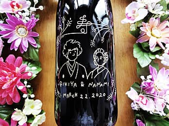 「お客様がデザインしたイラスト」を一升瓶の側面に彫刻した、結婚祝いのプレゼント用の日本酒