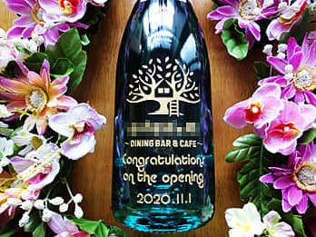 「ロゴマーク」と「Congratulations on the opening」を側面に彫刻した、飲食店の開店祝い用のシャンパン