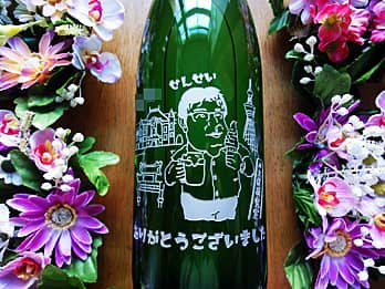 お客様が描いたイラストを、一升瓶の側面に彫刻した日本酒