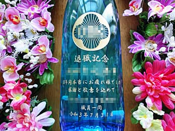 定年退職祝い用の日本酒（会社のロゴマークと、退職記念 ○○様 感謝と敬意を込めて ○○職員一同を、一升瓶の側面に彫刻）