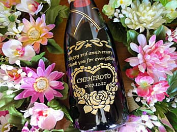 「Happy 3rd anniversary、奥さまの名前」を側面に彫刻した、結婚記念日の贈り物用のシャンパンボトル