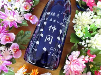 「桜の花のイラスト、新郎と新婦の名前、贈り主の名前」をボトル側面に彫刻した、結婚祝い用のワイン