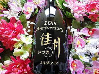 「10th anniversary、お店のロゴ、日付」を側面に彫刻した、周年祝い用のシャンパンボトル