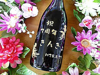 「祝3周年、お店の名前、金魚のイラスト」をボトル側面に彫刻した、周年祝い用のシャンパン