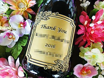 「Thank you、先生の名前、卒業年度と学校名」をボトル側面に彫刻した、同窓会で恩師へ贈るプレゼント用のシャンパン
