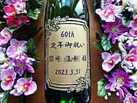「60th、定年御祝い、退職する方の名前、退職日の日付」を一升瓶の側面に彫刻した、定年祝い用の日本酒