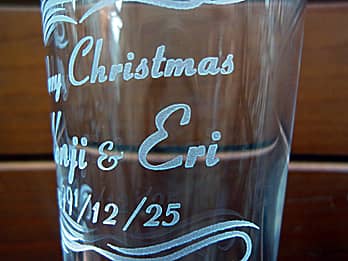 クリスマスプレゼント用のグラス側面に彫刻した「メッセージ、贈る相手の名前、クリスマスの日付」のクローズアップ画像