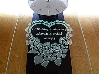 「1st Wedding Anniversary、旦那様と奥様の名前、結婚記念日の日付」を前面ガラスに彫刻した、結婚記念日祝い用の掛け時計