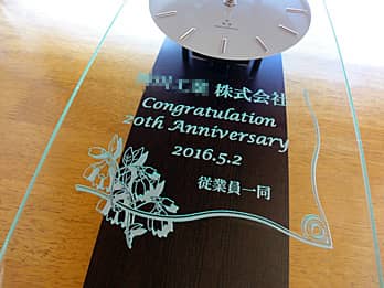 「○○株式会社、Congratulations 20th anniversary、日付、従業員一同」を前面ガラスに彫刻した、創立20周年記念用の掛け時計