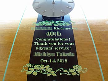 「勤続年数と先生の名前」を彫刻した、幼稚園教諭の永年勤続表彰用の掛け時計
