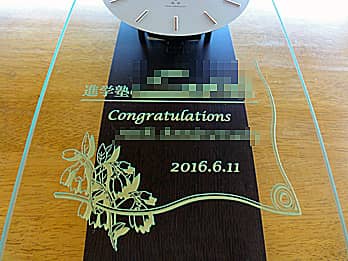 「進学塾のロゴマーク、Congratulations、合格者の名前」を前面ガラスに彫刻した、志望校の合格記念品用の掛け時計