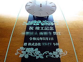 「祝 竣工記念、○○賛江、株式会社○○与利」を彫刻した、竣工祝い用の掛け時計