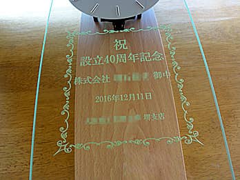 「祝 設立40周年記念、贈り先の会社名、日付、贈り主の会社名」を彫刻した、お取引先の周年祝い用の掛け時計