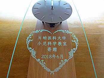 「○○医科大学寄贈、日付」を前面ガラスに彫刻した、開院祝い用の掛け時計